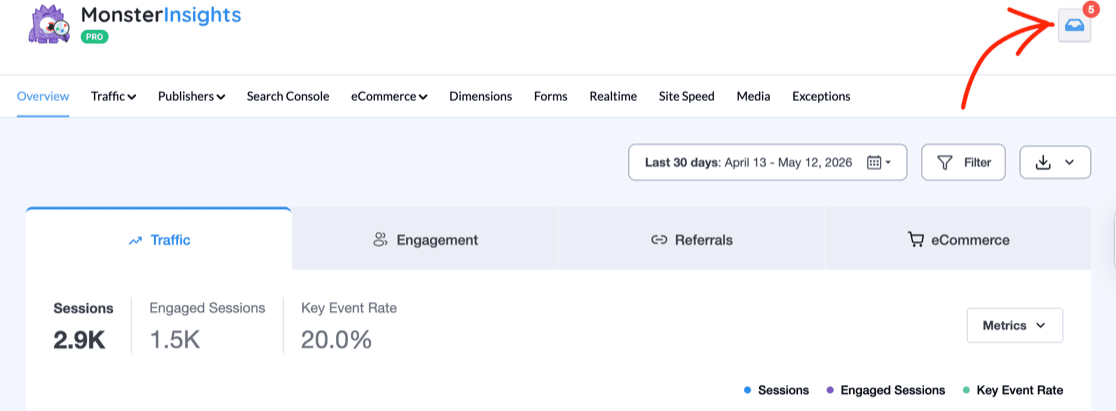 charlie-chat-10 - MonsterInsights MonsterInsights dashboard header with a red arrow pointing to the notification bell icon in the top right corner